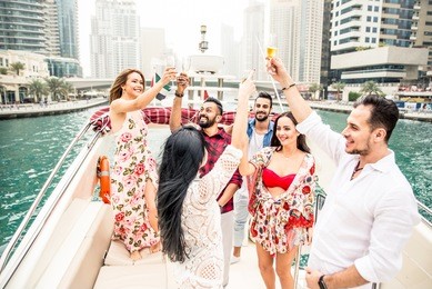 group of friends making party on a yacht in dubai. motivational concept about friendship and party mood