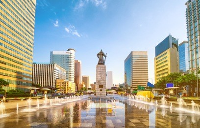 sunset of gwanghwamun plaza with the statue of the admiral yi sun-sin and modern buildings in downtown seoul,south korea. 