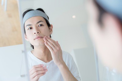 men's beauty concept. asian boy checking his skin.