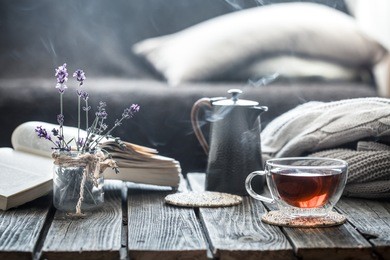 still life book and a cup of tea in the living room on a wooden table, the concept of coziness and interior