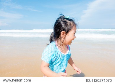 little asian girl walking and stand on sea sand on the beach.vacation and relax concept.playful active kid on beach in summer vacation.