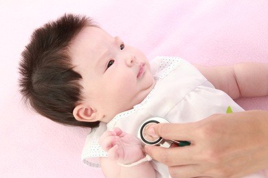 doctor exams baby with stethoscope