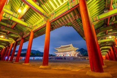 gyeongbokgung palace at night in south korea, with the name of the palace 'gyeongbokgung' on a sign