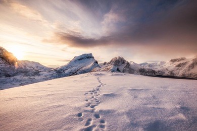 landscape of snow mountains range with footprint on snowy at sunrise morning