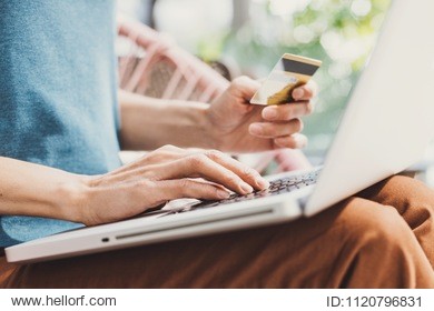 young woman holding credit card and using laptop computer, travel and online shopping concept