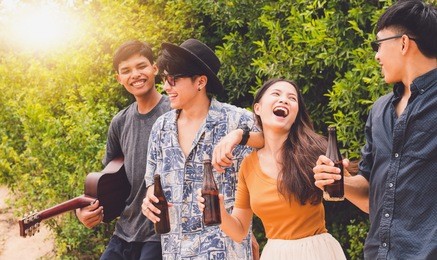 group of asian teenager have party and drinks beer on the beach