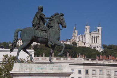 view of the equestrian statue of louis xiv and the basilica of notre dame de fourviere from place bellecour, in the center of lyon
