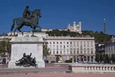 view of the equestrian statue of louis xiv and the basilica of notre dame de fourviere from place bellecour, in the center of lyon