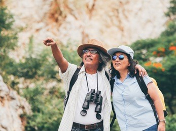 senior couple travel on a summer vacation.they are holding hands and hiking together.