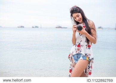 asian woman enjoy take photo by digital camera at beach. single and lonely woman concept. happiness and lifestyle concept. beauty and nature theme. ocean and sea background. technology and woman day