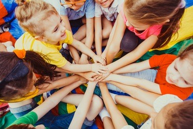 group of children putting their hands together