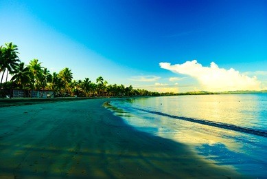 family friend enjoying beautiful colorful colourful sunset at denarau island sandy beach in fiji with palm trees and blue sky for holiday vacation couple honey moon retreat