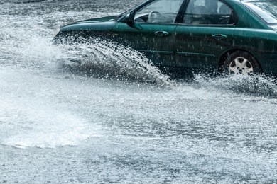 splashes of rain water from car wheels during heavy rain