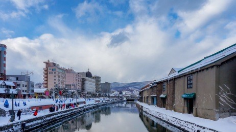 beautiful view of old warehouse at otaru canal in sapporo, hokkaido, japan with snow cover on roof. traveler traveling at otaru canal is one of most famous place in sapporo, hokkaido, japan in winter