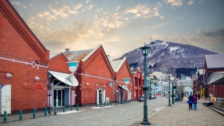 cityscape of the historic red brick warehouses and mount hakodate ropeway at sunset on hakodate mountain at hakodate near sapporo, hokkaido japan at winter