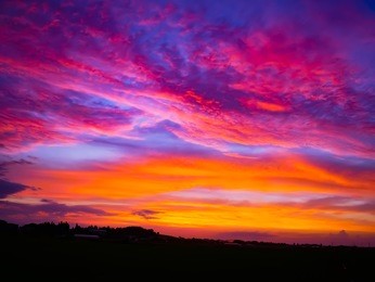 natural sunset in evening rise field silhouette at south korea. bright dramatic sky and dark ground. countryside landscape under scenic colorful sky at sunset. sun over skyline, horizon. warm colors