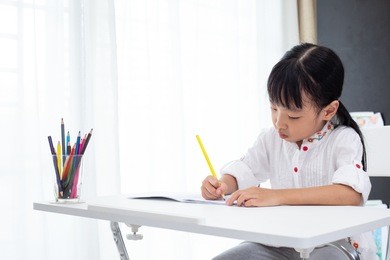 asian little chinese girl doing homework at home