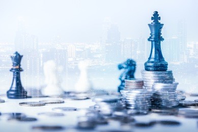 double exposure image of the coin stack which has the staunton chess set such as king on top and overlay with cityscape image. the concept of accounting, business, financial, economy and investment.