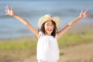 portrait of happy young little girl in the beach laughing