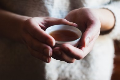 the girl's hands hold the tea bowl.