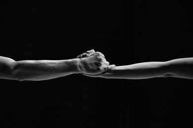 couple holding hands in the dance. male and female hands close-up on a black background. minimalism, geometry, line. bw.