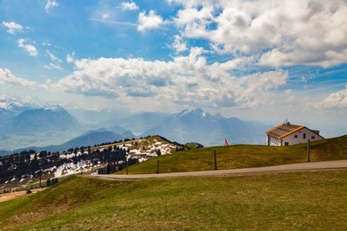 green grass field on top of rigi kulm luzern switzerland with alps snow mountain view and sky
