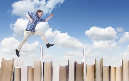 man jumping over books