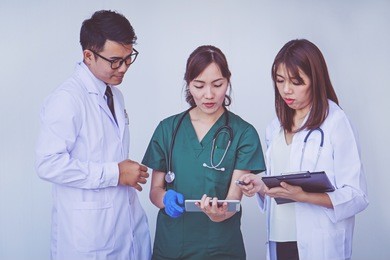 doctor and nurse checking patient information on a tablet device