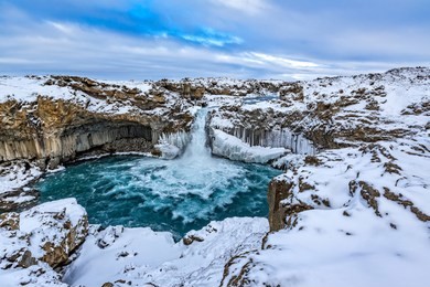 extreme wide shot of aldeyjarfoss in winter with lots of ice and