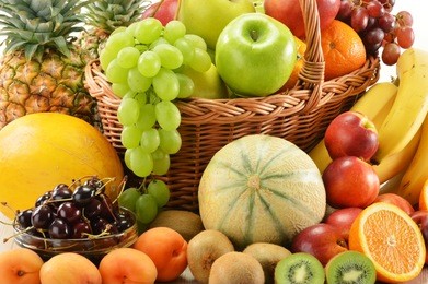 composition with assorted fruits in wicker basket isolated on white