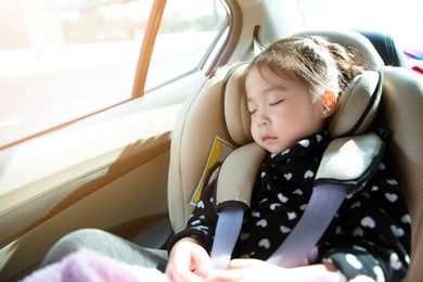 asian little girl sleeping in car with car seat