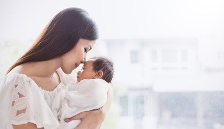 closeup portrait of beautiful young asian mother kissing her newborn baby. healthcare and medical family love lifestyle mother’s day concept panoramic banner