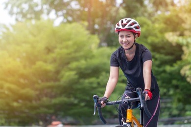 young female cyclist in professional cycling clothing riding bike at stadium .  eco friendly trendy city bike to work .