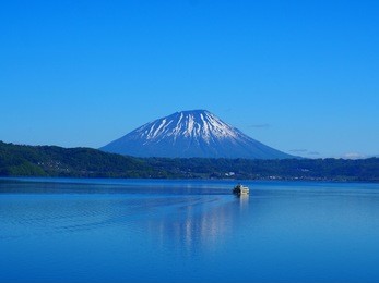 a tourist ship in toya lake with yotei mountain background