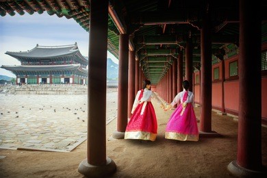 korean lady in hanbok or korea gress and walk in an ancient town and gyeongbokgung palace in seoul, seoul city, south korea.