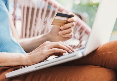 young woman holding credit card and using laptop computer. travel, business, internet banking, e-commerce and online shopping concept