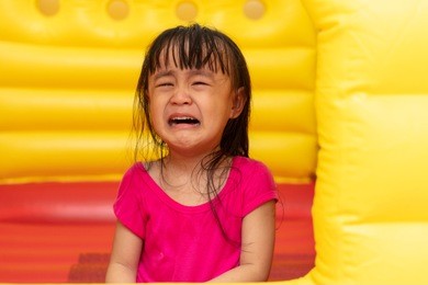 asian little chinese girl playing at inflatable castle at indoor playground