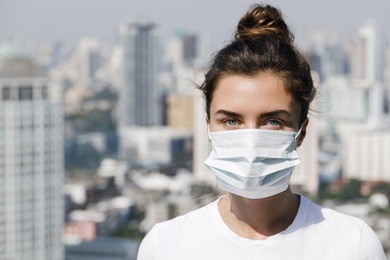 woman wearing face mask because of air pollution or virus epidemic in the city