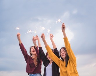 happy group of asian girl friends enjoy and play sparkler at roof top party at evening sunset,holiday celebration festive,teeage lifestyle,freedom and fun