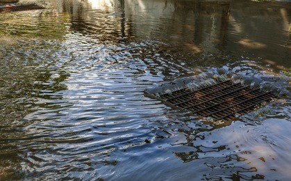 flow of water during heavy rain and clogging of street sewage. the flow of water during a strong hurricane in storm sewers. sewage storm system along the road to drain rain into the drainage system