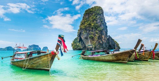 amazing view of beautiful beach with longtale boats. location: railay beach, krabi, thailand, andaman sea. artistic picture. beauty world.