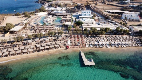 aerial drone bird's eye view from famous beach of paraga featuring famous night club of skorpios and santanna with largest pool in europe, mykonos island, cyclades, greece