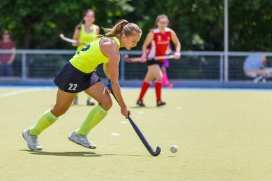 young hockey player woman with ball in attack playing field hockey game