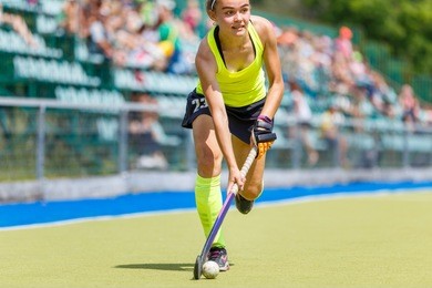young hockey player woman with ball in attack playing field hockey game