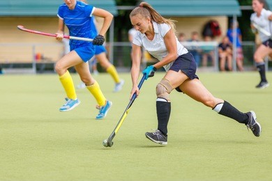 young hockey player woman with ball in attack playing field hockey game