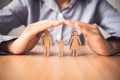 hand protecting the icon family people   - the concept of insurance.