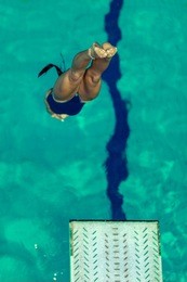 female diver jumping into the pool from diving board