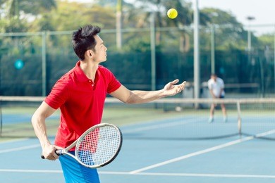 chinese professional tennis player ready to hit the ball with the racket after tossing while serving in the beginning of a difficult match
