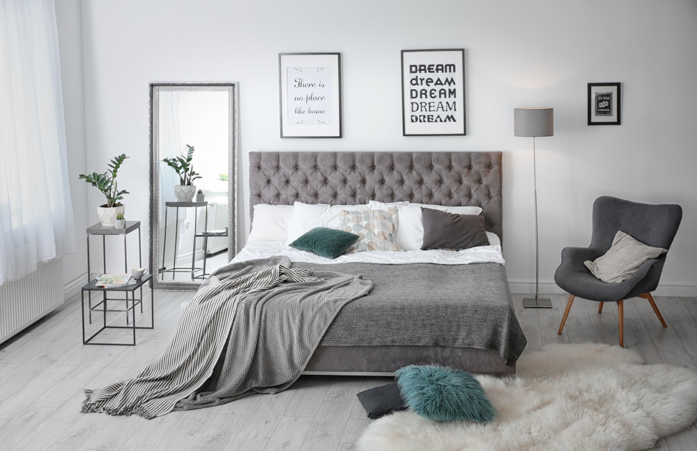 elegant room interior with large comfortable bed and armchair