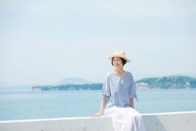 asian woman sitting down on the breakwater